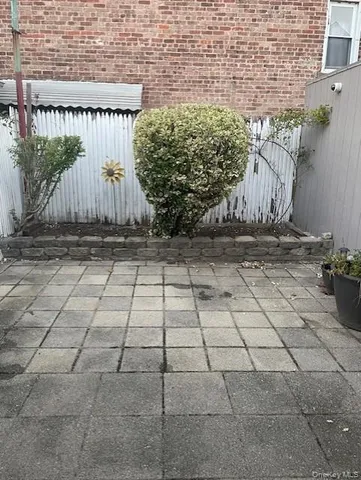a view of a pathway with a brick wall