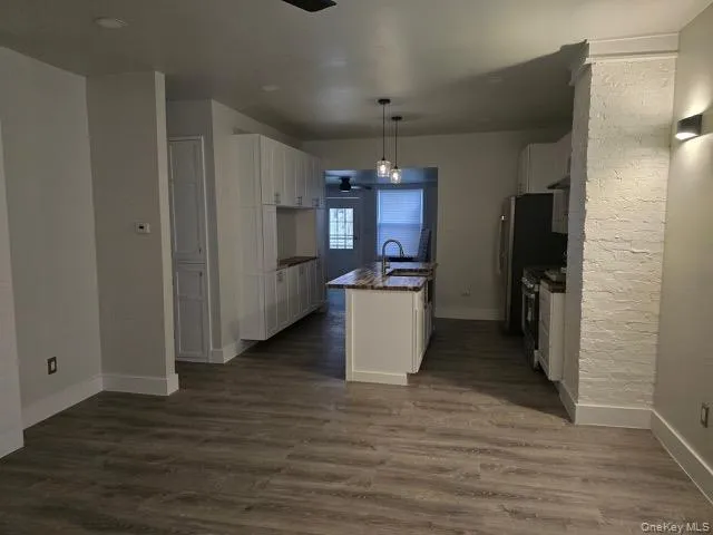 a view of a kitchen with refrigerator and wooden floor