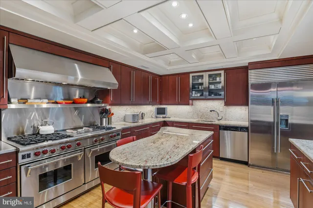a kitchen with stainless steel appliances granite countertop a sink table and chairs