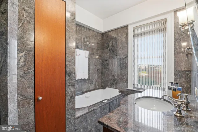 a bathroom with a granite countertop shower a mirror and sink