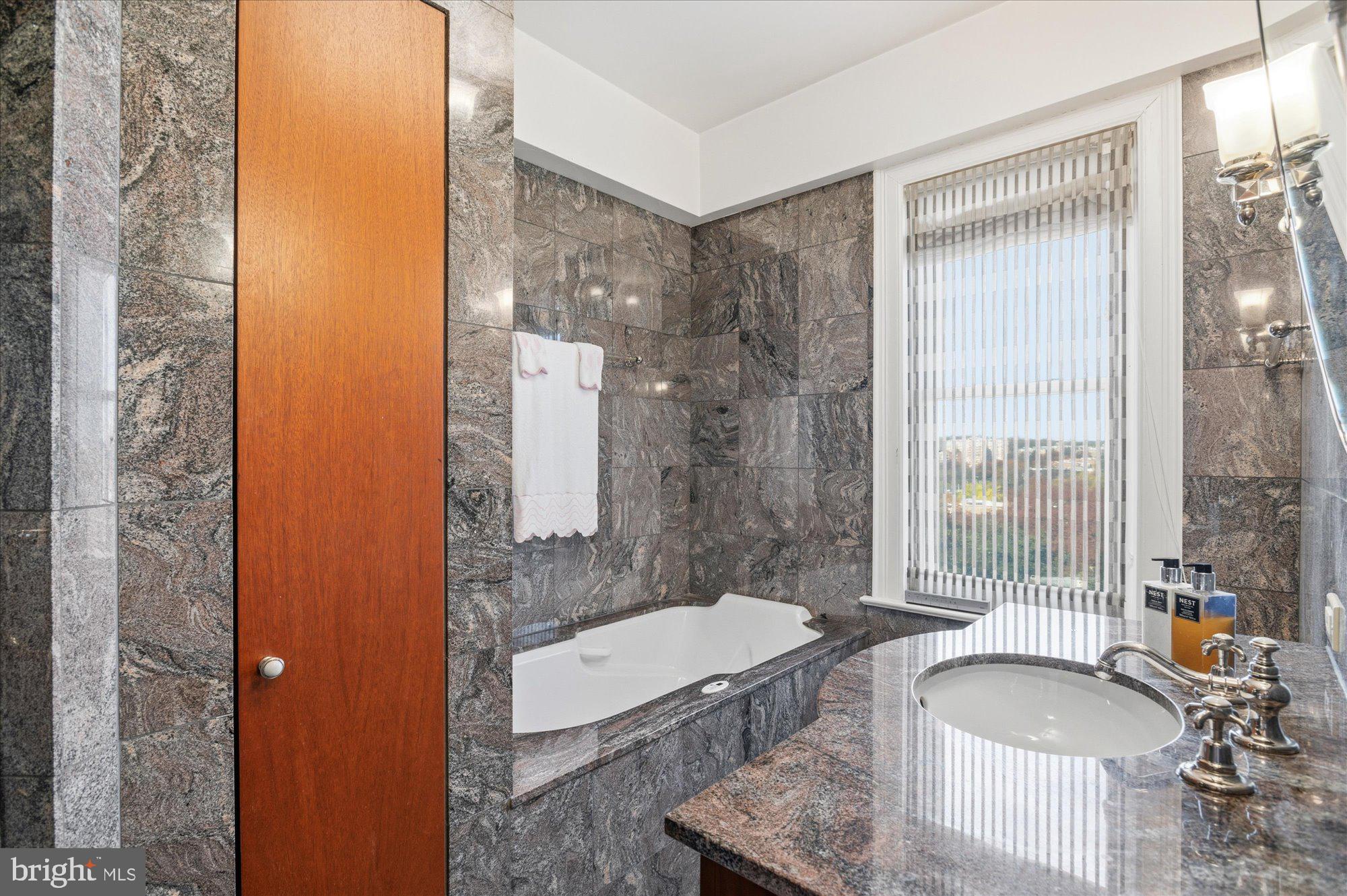 2101 Connecticut Avenue Northwest, Unit 78 Washington, DC 20009 - Photo 22 of 53 a spacious bathroom with a granite countertop tub sink and mirror