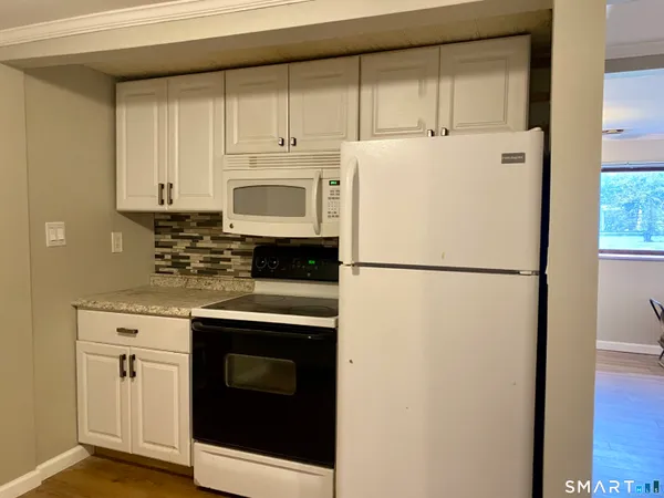 a kitchen with refrigerator a stove a microwave and cabinets