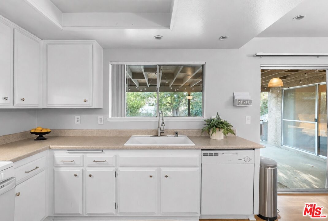 29357 Reading Road Menifee, CA 92586 - Photo 9 of 46 a kitchen with granite countertop white cabinets and a window