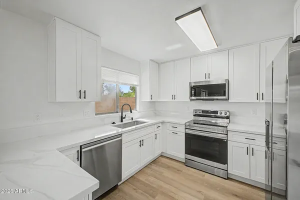 a kitchen with stainless steel appliances a white stove top oven and sink