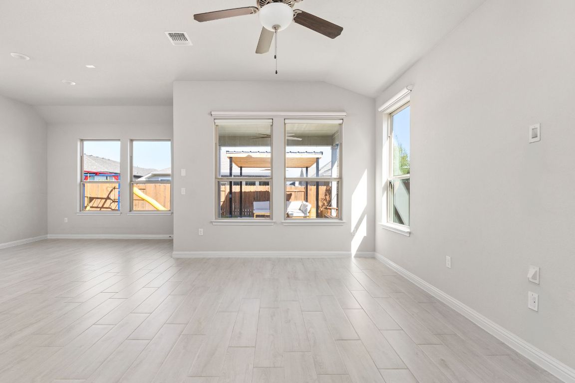 8408 Orizzonte Street Austin, TX 78744 - Photo 11 of 31 an empty room with wooden floor and windows