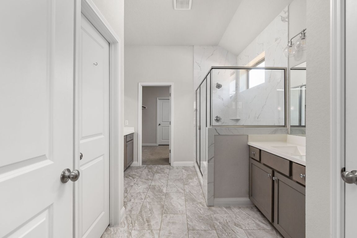 8408 Orizzonte Street Austin, TX 78744 - Photo 16 of 31 a bathroom with a granite countertop sink mirror and shower