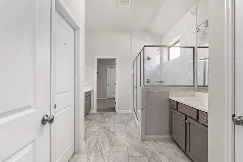 a bathroom with a granite countertop sink mirror and shower