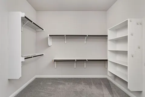 a view of walk in closet with empty racks