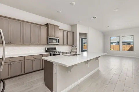 a kitchen with stainless steel appliances granite countertop a sink and dishwasher a stove top oven with wooden floor