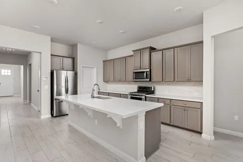 a kitchen with stainless steel appliances a refrigerator stove microwave and cabinets