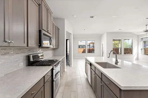 a kitchen with a sink stove top oven and refrigerator