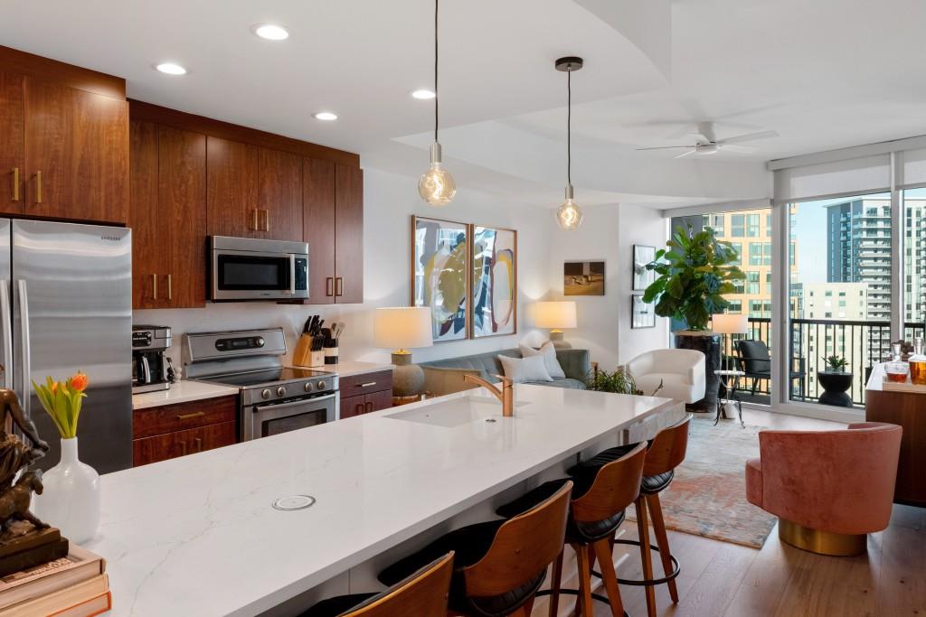 1080 Peachtree Street Northeast, Unit 1906 Atlanta, GA 30309 - Photo 1 of 46 a kitchen with stainless steel appliances granite countertop a stove a refrigerator a kitchen island a dining table and chairs