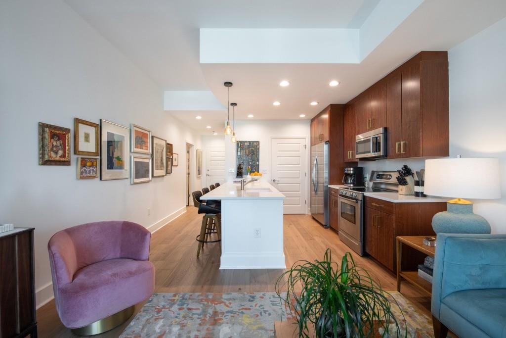 1080 Peachtree Street Northeast, Unit 1906 Atlanta, GA 30309 - Photo 10 of 46 a large living room with stainless steel appliances kitchen island granite countertop furniture and a kitchen view