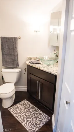 a bathroom with a granite countertop toilet and a sink