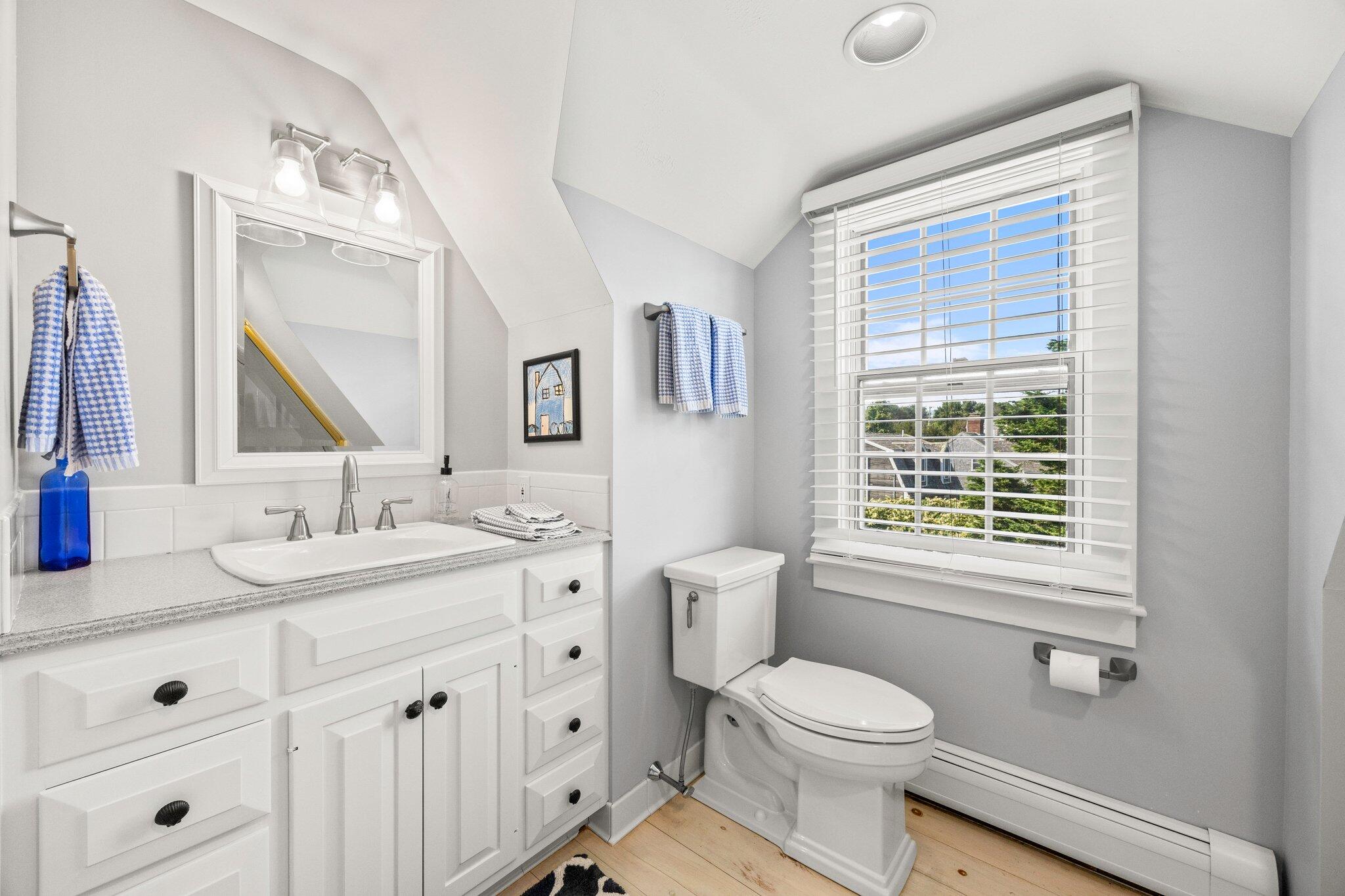 47 Quasson Road Chatham, MA 02633 - Photo 23 of 47 a bathroom with a toilet a sink a mirror a window and vanity
