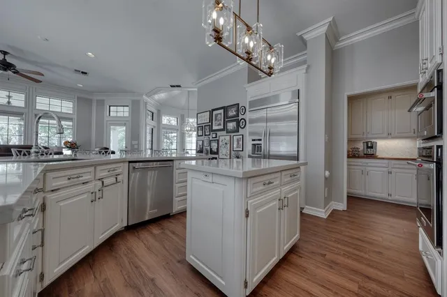 a kitchen with white cabinets stainless steel appliances and sink