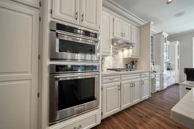 a kitchen with granite countertop white cabinets stainless steel appliances and sink