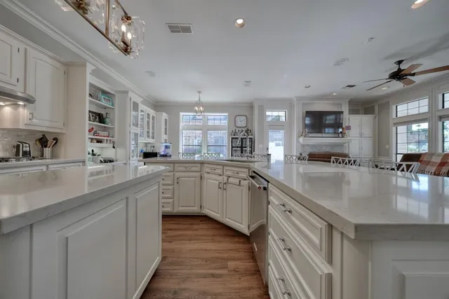 a large white kitchen with lots of counter space and a sink