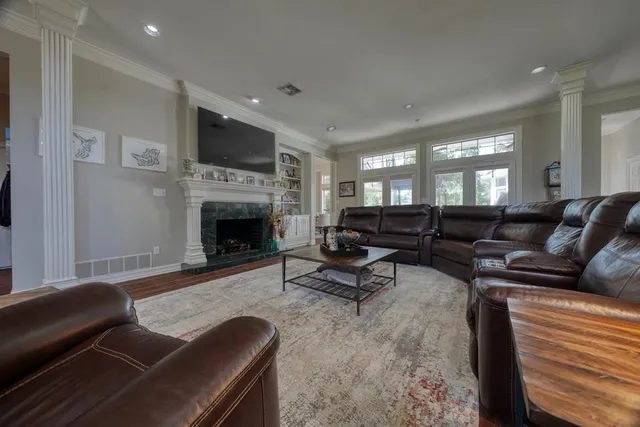 a living room with furniture a flat screen tv and a fireplace
