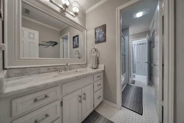 a bathroom with a granite countertop sink a mirror a vanity and a shower