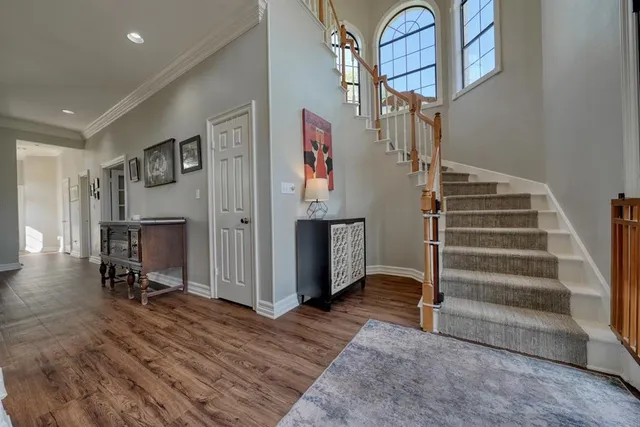 a view of a hallway with wooden floor and staircase