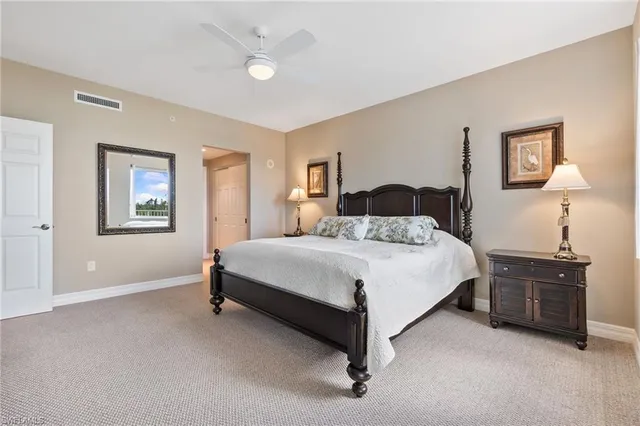 a bedroom with a bed and a lamp on dresser