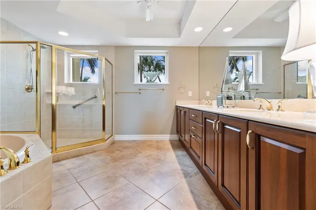 a bathroom with a double vanity sink a large mirror a shower and bathtub