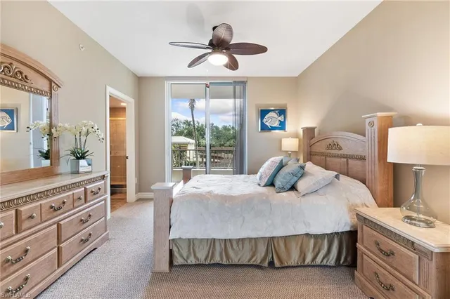 a bedroom with a large bed and a chandelier fan