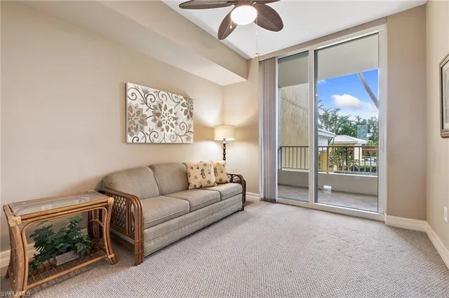 a living room with furniture a ceiling fan and a window