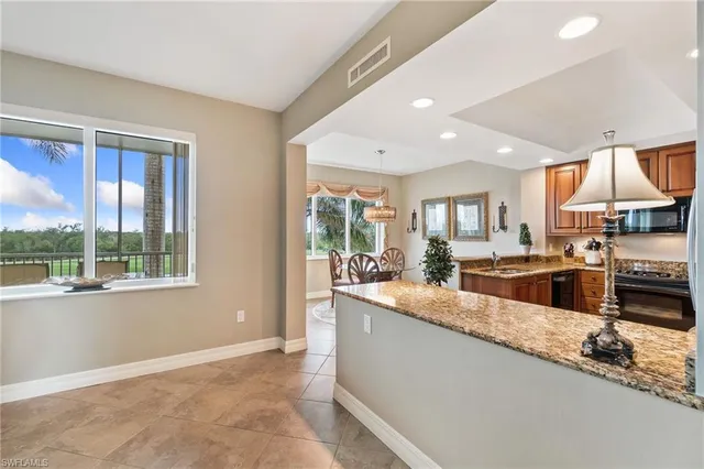 a large kitchen with granite countertop a large window and stainless steel appliances