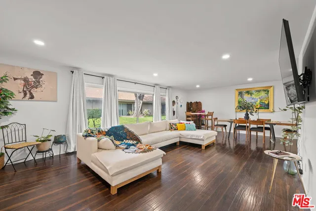 a living room with furniture flat screen tv and wooden floor