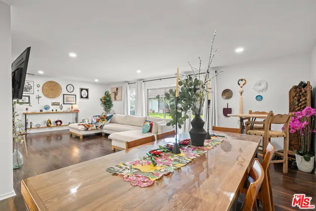 a living room with furniture kitchen view and a large window