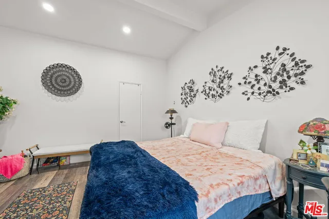 a bedroom with a bed and a table with wooden floor