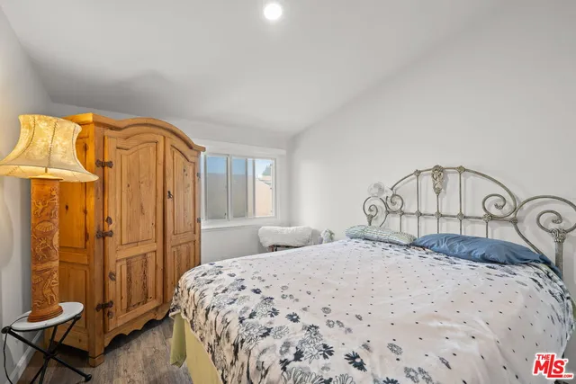 a bedroom with a bed a table and painting on the wall