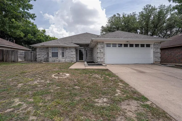 a front view of house with yard and trees in the background