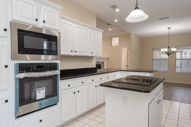 a kitchen with granite countertop white cabinets white stainless steel appliances and a granite counter tops