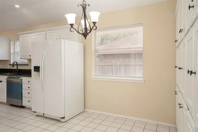 a view of a kitchen with white cabinets and refrigerator