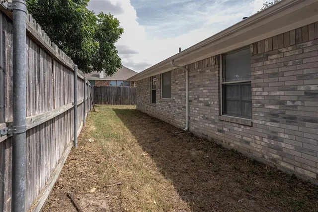 a view of backyard with wooden fence and large trees