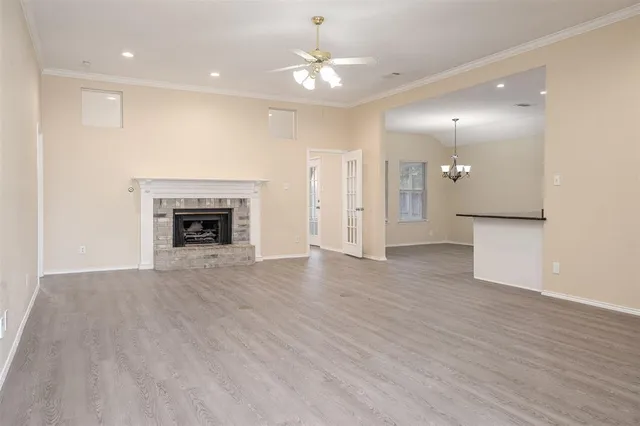 an empty room with a fireplace and wooden floor