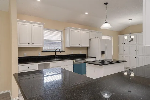 a kitchen with stainless steel appliances granite countertop a sink a stove and a refrigerator