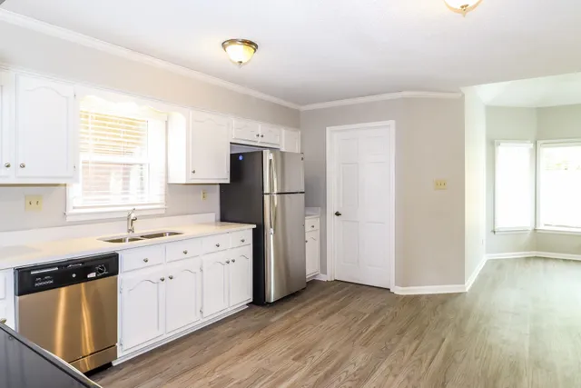a kitchen with a refrigerator sink and cabinets