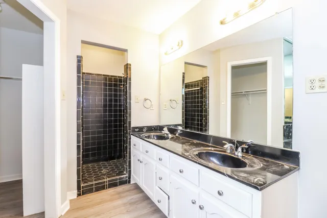 a bathroom with double sink and a mirror