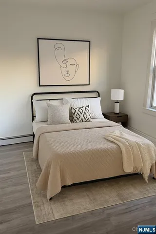 a bedroom with a bed and painting on the wall