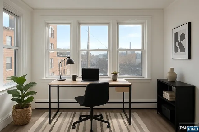 a view of a workspace with furniture and a window