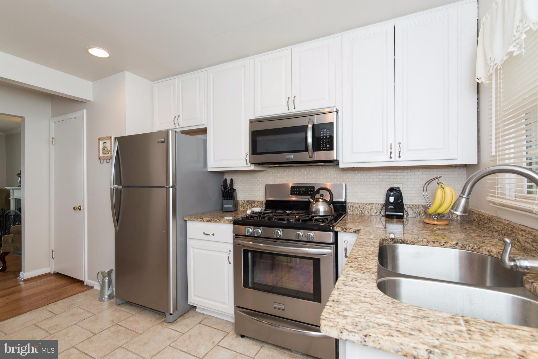 7104 Bexhill Road Baltimore, MD 21244 - Photo 3 of 28 a kitchen with stainless steel appliances granite countertop a refrigerator stove and sink