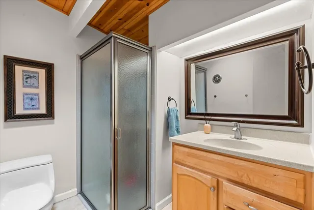 a bathroom with a granite countertop sink a mirror and a shower