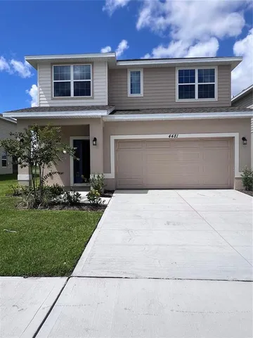 a front view of a house with a yard and a garage