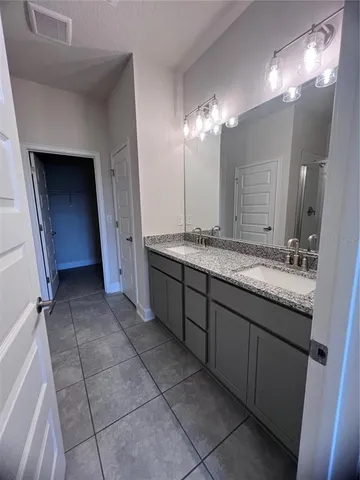 a bathroom with a double vanity sink and a mirror
