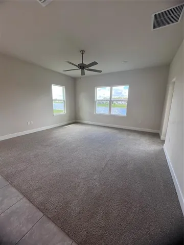 an empty room with a window and a ceiling fan