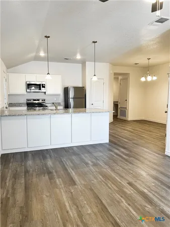 a large kitchen with cabinets a sink and a stove